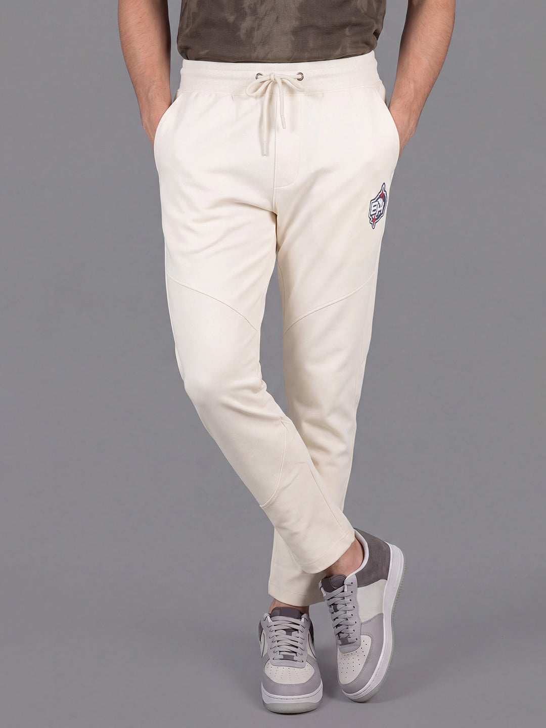 Cream Loose Regular Fit Solid Cotton Blend Mid Rise Men's Track Pants by Being Human Clothing