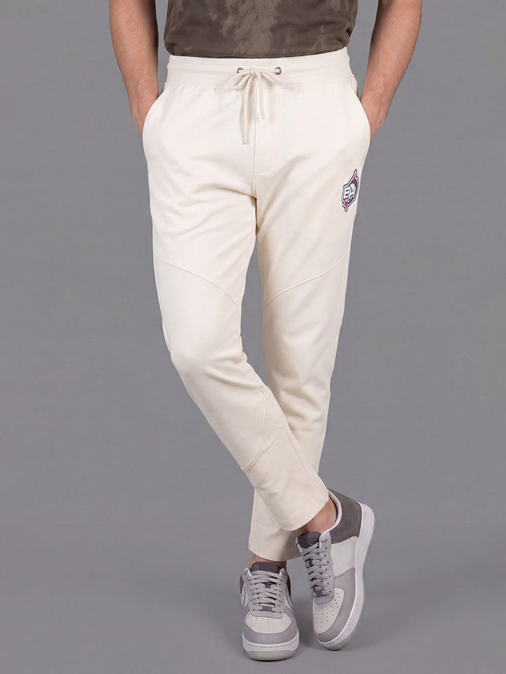 Cream Loose Regular Fit Solid Cotton Blend Mid Rise Men's Track Pants by Being Human Clothing