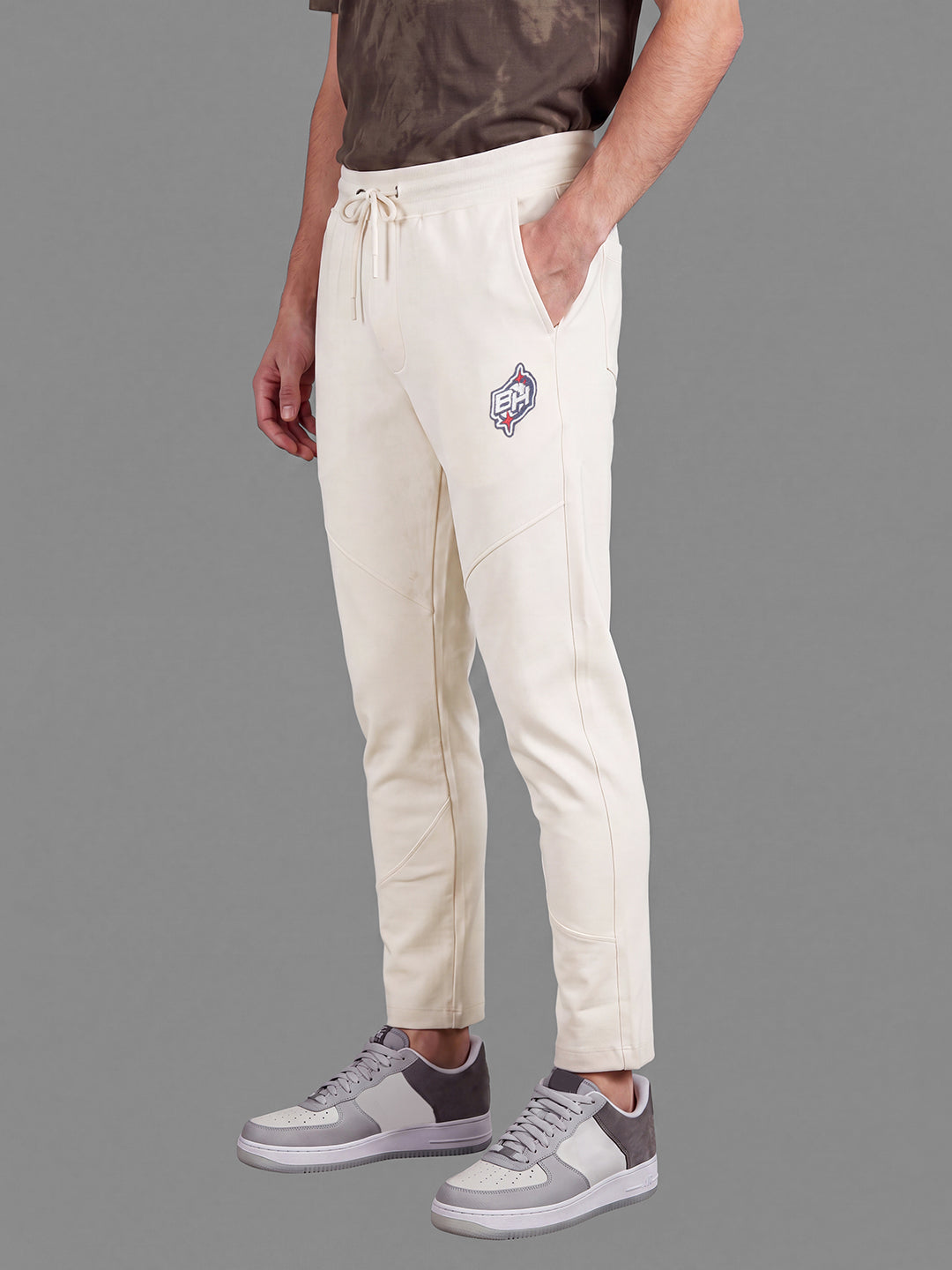 Cream Loose Regular Fit Solid Cotton Blend Mid Rise Men's Track Pants by Being Human Clothing