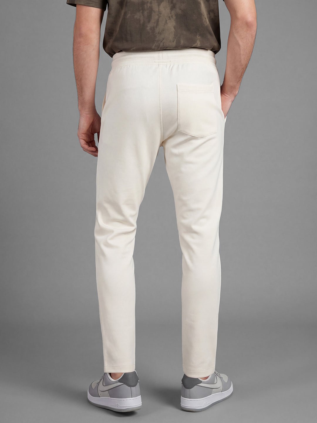 Cream Loose Regular Fit Solid Cotton Blend Mid Rise Men's Track Pants by Being Human Clothing